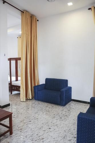 a living room with a blue couch and a window at Sunset View Beach Hotel in Arugam Bay