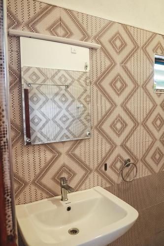 a bathroom with a sink and a mirror at Sunset View Beach Hotel in Arugam Bay