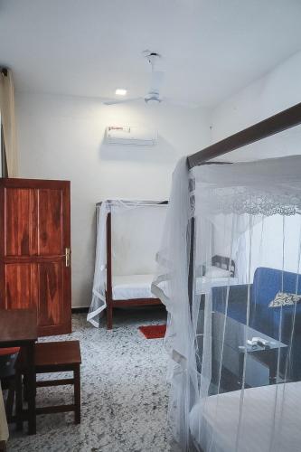 a bedroom with a bed with mosquito nets on it at Sunset View Beach Hotel in Arugam Bay