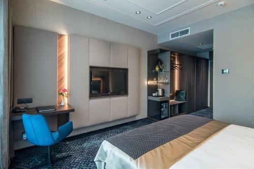 a hotel room with a bed and a television at Sky Blue Hotel & Spa in Ploieşti