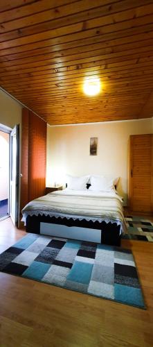 a bedroom with a large bed with a wooden ceiling at Vila Coca in Predeal