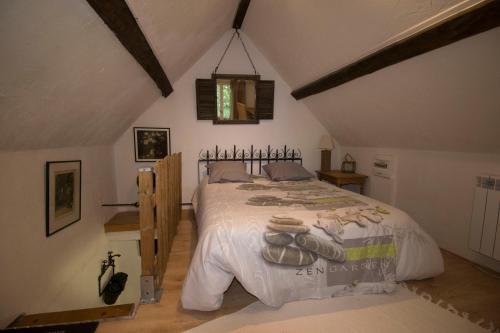 ein Schlafzimmer mit einem großen Bett im Dachgeschoss in der Unterkunft ANNEXE DU PARC 1 in Vimoutiers