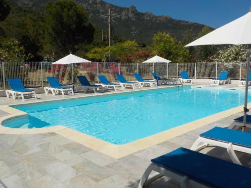 une piscine avec des chaises bleues et des parasols dans l'établissement Hotel Cinque Arcate, à Galéria