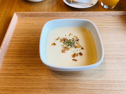a bowl of soup sitting on a wooden tray at MY LODGE Naoshima in Naoshima