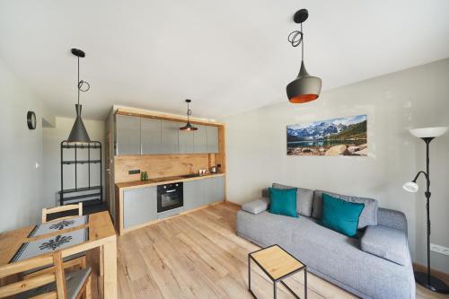 a living room with a couch and a table at Apartamenty SZAROTKA Nowy Targ in Nowy Targ