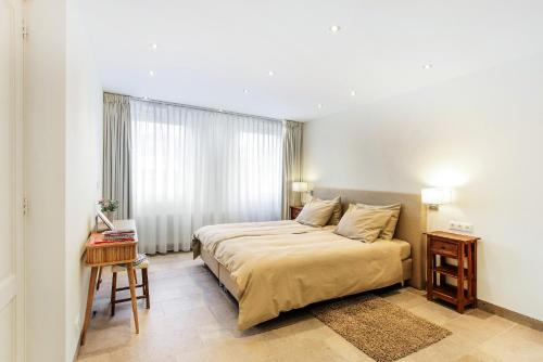 um quarto com uma cama, uma mesa e uma janela em Artis Plantage Apartment em Amsterdã
