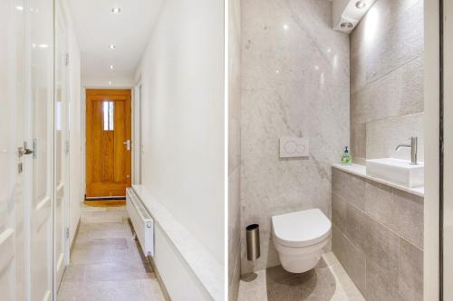 a white bathroom with a toilet and a sink at Artis Plantage Apartment in Amsterdam