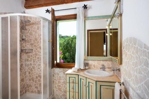 a bathroom with a sink and a mirror and a shower at Villetta a Cannigione in Cannigione