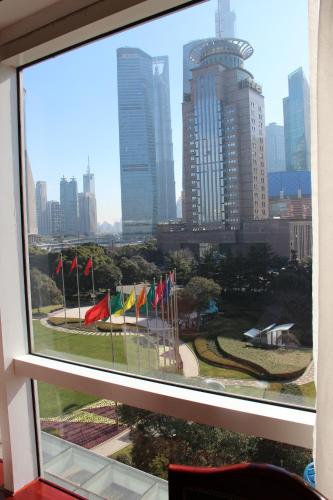 a view of a city from a window with flags at Oriental Riverside Bund View Hotel (Shanghai International Convention Center) in Shanghai