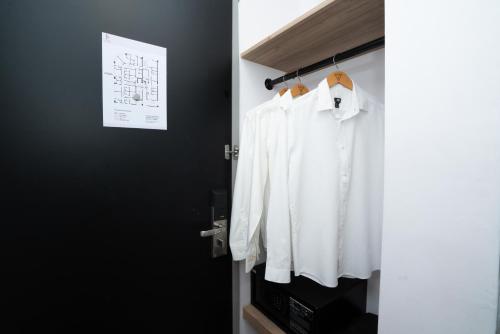 a closet with white shirts hanging on a black wall at B Lot Hotel in Kuala Lumpur