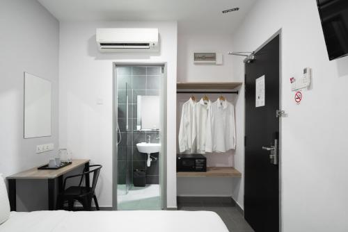 a bedroom with a bathroom with a sink and a mirror at B Lot Hotel in Kuala Lumpur
