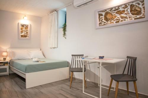 een kleine kamer met een bed en een tafel en stoelen bij Studio Cozy - In the Heart of Skyros Village in Skiros