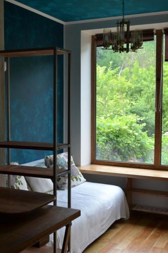 a bedroom with a bed and a large window at Romantic Guest House in Kamianets-Podilskyi