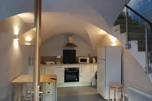 a kitchen with a white refrigerator and a table at Maison de bourg in Vic-le-Comte
