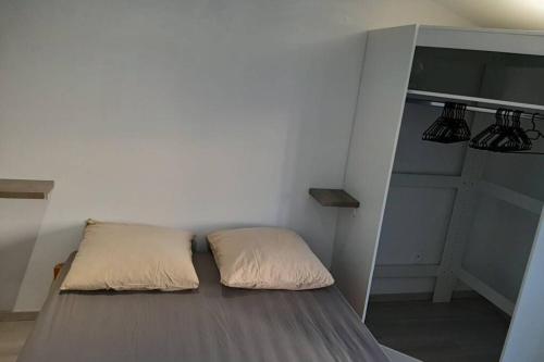 un lit avec deux oreillers dessus dans une chambre dans l'établissement Maison de bourg, à Vic-le-Comte