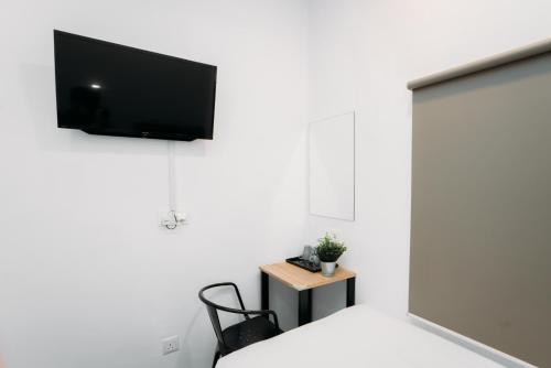 a room with a flat screen tv on a white wall at B Lot Hotel in Kuala Lumpur