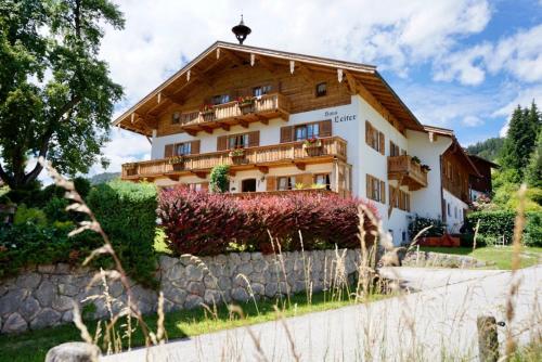 a house in the mountains with a stone wall at Haus Leiter in Reit im Winkl