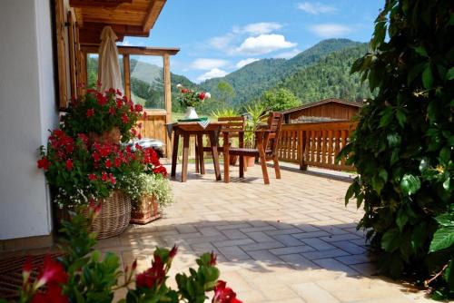 a patio with a table and chairs and flowers at Haus Leiter in Reit im Winkl