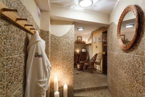 a bathroom with candles and a towel and a mirror at Willa Pastel in Białystok