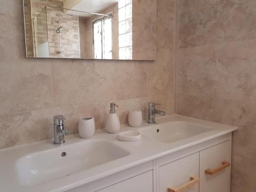 La salle de bains est pourvue d'un lavabo blanc et d'un miroir. dans l'établissement SANTA BARBARA APARTAMENTO, à Alicante