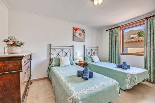 a bedroom with two beds and a window at Ca n Tres Cames Cuxach de n Joan in Pollença