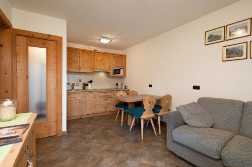 a kitchen and living room with a table and a couch at Chalet Mistral in Livigno