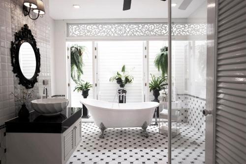 a white bathroom with a tub and a sink at Noursabah Pattaya in Pattaya Central