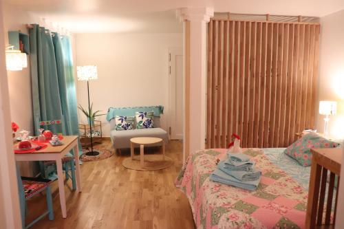 a bedroom with a bed and a table and a couch at Le studio de Manoline in Bourges