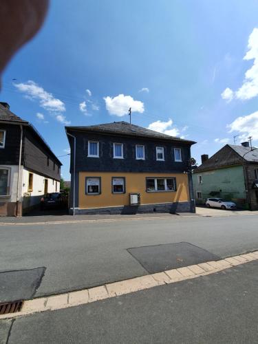 a yellow and blue house on the side of a street at Gästehaus Weißes Lamm - MONTEURZIMMER in Nordhalben