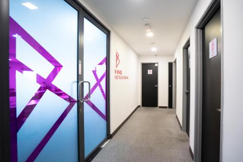 a corridor of an office with a door with purple arrows at B Lot Hotel in Kuala Lumpur