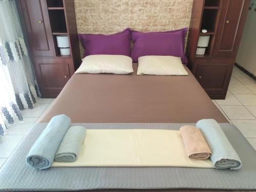 a bedroom with two beds with purple and white pillows at Sweet Home in Athens