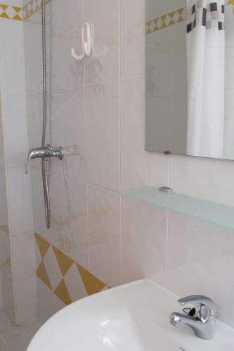 a bathroom with a sink and a shower with a mirror at Ático con terraza en Graus-Pirineo de Huesca in Graus