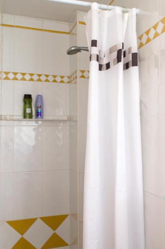 a white shower curtain in a bathroom with a shower at Ático con terraza en Graus-Pirineo de Huesca in Graus
