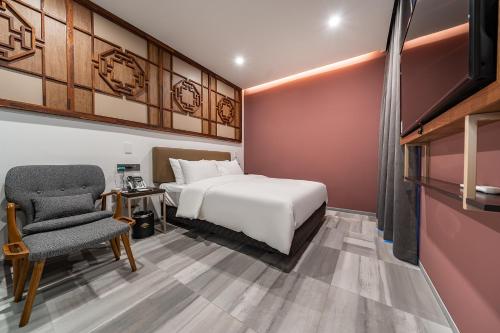 a bedroom with a white bed and a chair at Hotel RU136 in Seoul