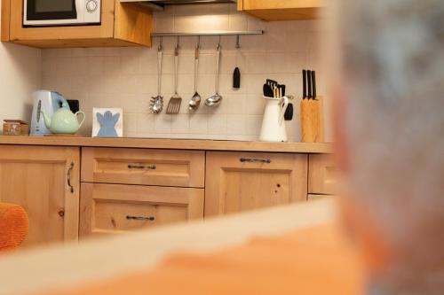 a kitchen with wooden cabinets and utensils at Chalet Mistral in Livigno
