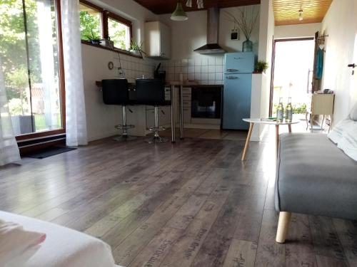 a living room with a wooden floor and a kitchen at Schöne EinZimmer Wohnung Zwischen Bodensee und Allgäu in Neukirch