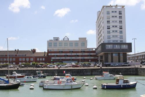 a group of boats docked in a harbor with buildings at Holiday Inn Calais-Centre by IHG in Calais