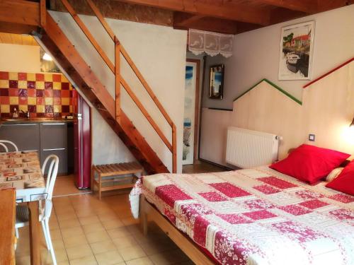 a bedroom with a bed and a staircase at Au Jardin près de l'ocean in Les Mathes