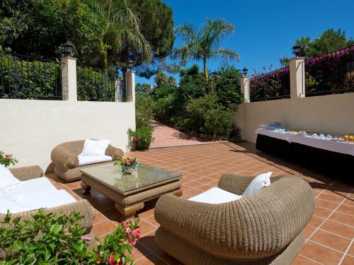 a patio with couches and a table and chairs at BlueBay Banús in Marbella