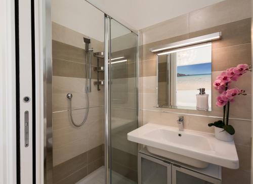 a bathroom with a sink and a shower at Coru e Mari - City Center & Private Parking in Pula
