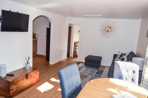 a living room with a table and chairs at Bluebell Cottage at The Old Tractor Barn in Brackley