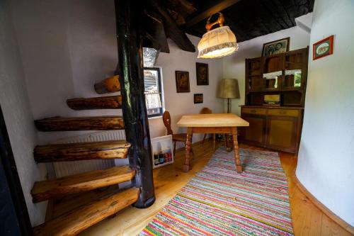 a room with a table and a staircase in a house at Casa Poveste Pensiunea-Muzeu in Câmpulung Moldovenesc