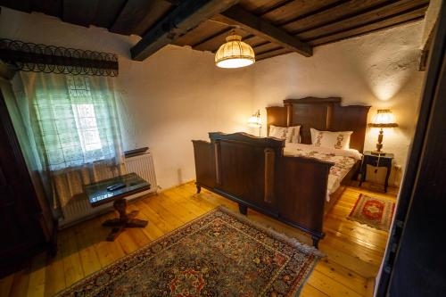 a bedroom with a bed and a table and a window at Casa Poveste Pensiunea-Muzeu in Câmpulung Moldovenesc