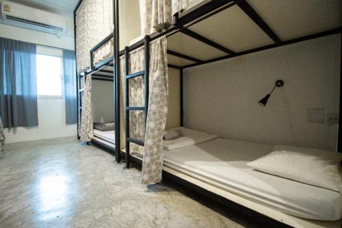 2 Etagenbetten in einem Zimmer mit Fenster in der Unterkunft 11:11 Hostel in Phra Nakhon Si Ayutthaya
