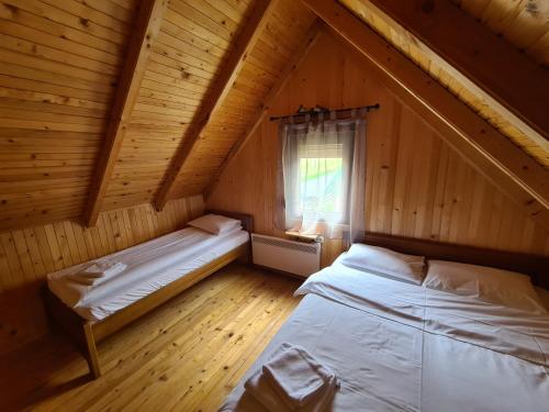 1 dormitorio en el ático con 2 camas y ventana en Black Pine en Žabljak