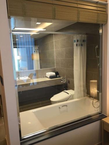 a bathroom with a tub and a toilet and a mirror at Hotel Regent Marine The Blue in Jeju