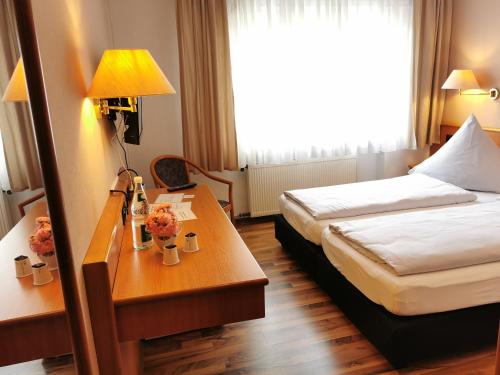 a hotel room with a bed and a table with a lamp at Hotel Mainperle in Wertheim