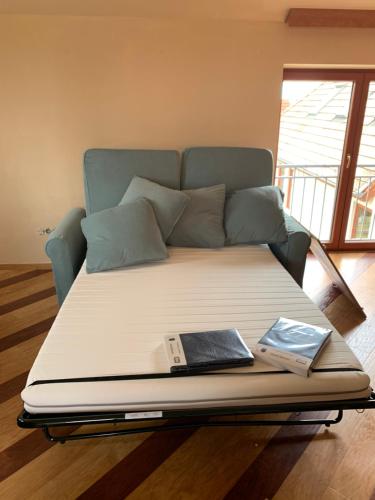 Un sofá con una cama con un libro. en Jakócs szállása en Balatonfüred