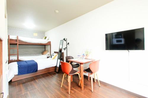 a bedroom with a bed and a table and chairs at Heights N7 / Vacation STAY 7568 in Sapporo