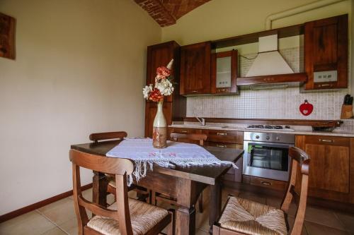 a kitchen with a table with a vase of flowers on it at Il Pozzo Fiorito in Cossombrato
